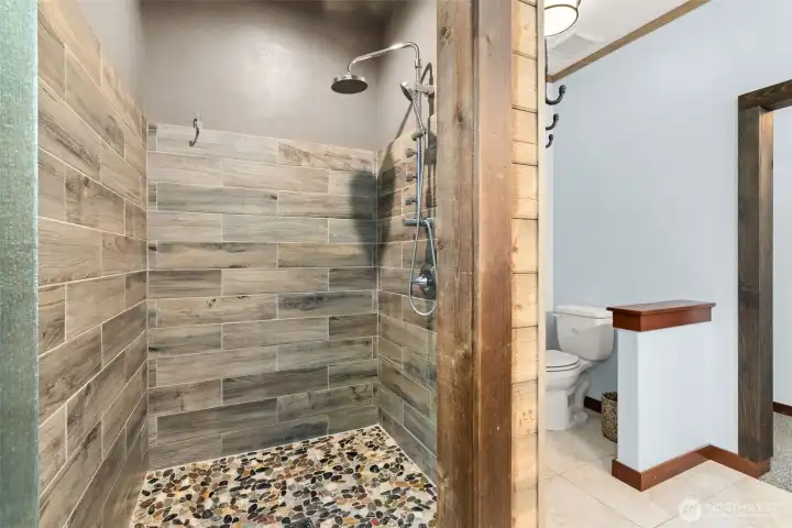 Full tile walk in shower with multiple shower heads.