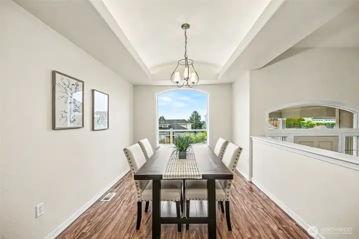 Dining area with natural light and backlit coved ceilings.