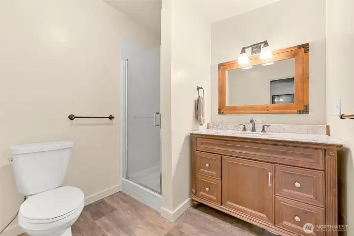 Updated bathroom featuring walk-in shower, spacious vanity, and modern finishes.