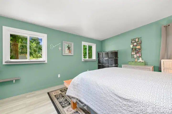 Spacious primary bedroom with dual windows, abundant natural light, and peaceful views.