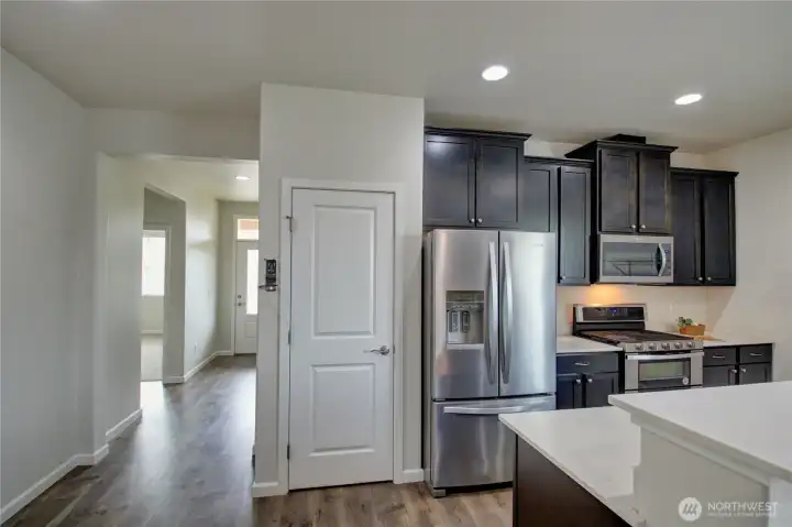 Hallway to the front door on left, pantry closet, gas range & stainless appliances.