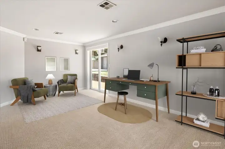 Bonus room/den just off the primary suite, currently staged as a work-from-home office with a sitting area.