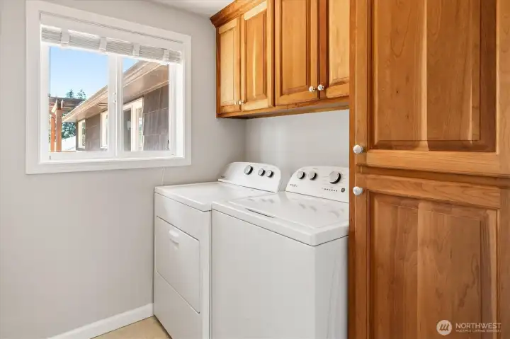 Utility room with full-size washer & dryer, fold down ironing board, plus plenty of storage.