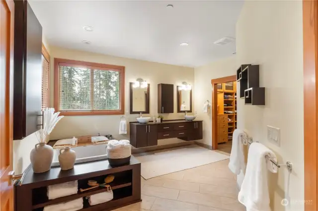 The Primary ensuite bathroom offers radiant floor heat to keep the toes warm! Contemporary floating cabinets compliment the vessel sinks. HUGE, jetted tub will easily accommodate two people.