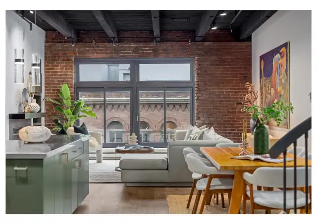 Living room with tall original timbered beam ceilings and historic exposed brick