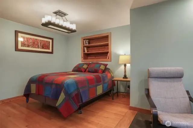Main (South) home upper level master bedroom suite with a sunroom addition featuring heated floors and southwest light, hardwood floors and custom built shelves and closet.