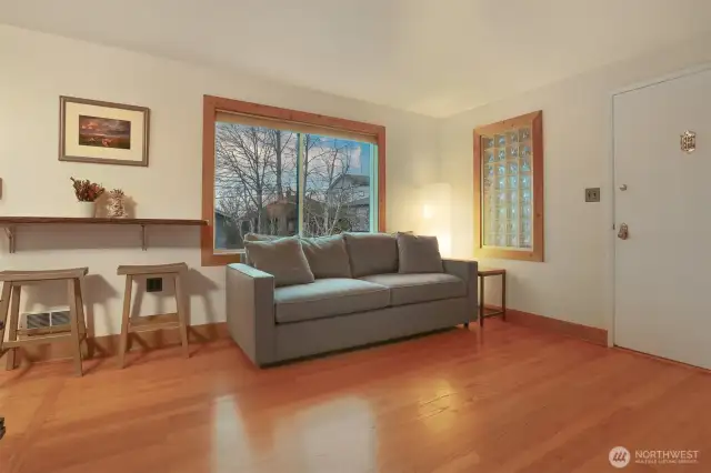 Main (South) home upper level living room with hardwood floors, bump out for entertainment center, woodstove and western exposure.