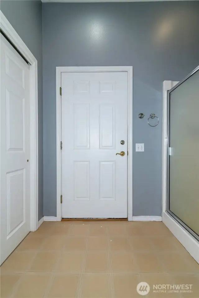 Downstairs entryway from garage with shower and closet storage