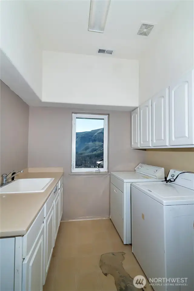 Downstairs laundry room with utility sink - furnace and hot water tank located in the closet