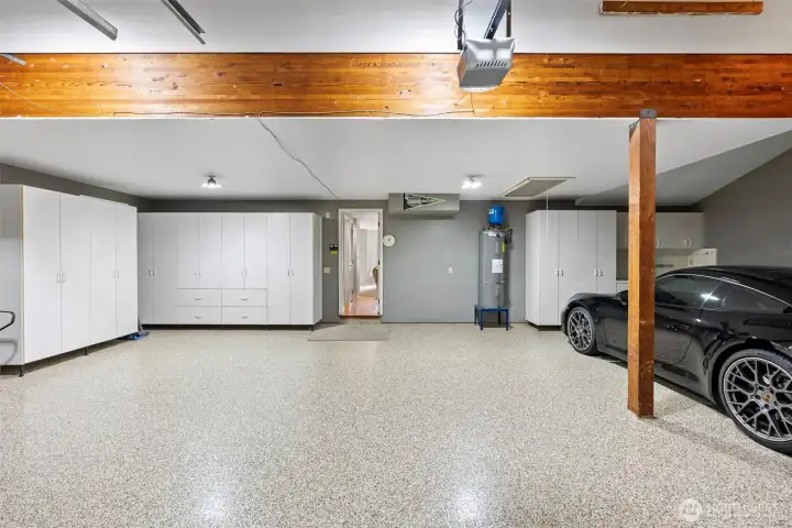 3 car garage with epoxy flooring and additional shelving.