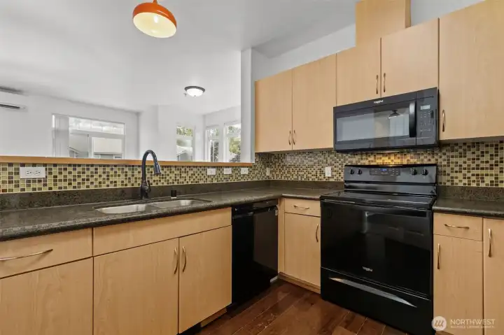 Modern kitchen with granite countertops, stainless steel appliances, and eating ba