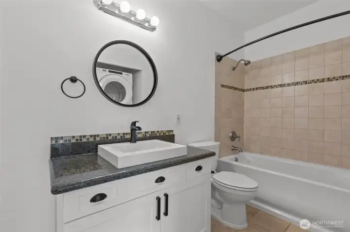 Luxurious bathroom with travertine floors, granite accents, and deep soaking tub