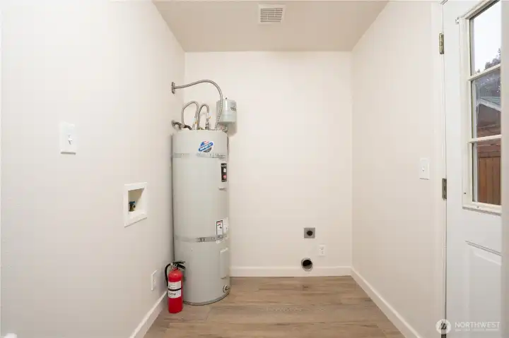 The utility room features a generous space for the washer and dryer as well as extra room for a panty cabinet.