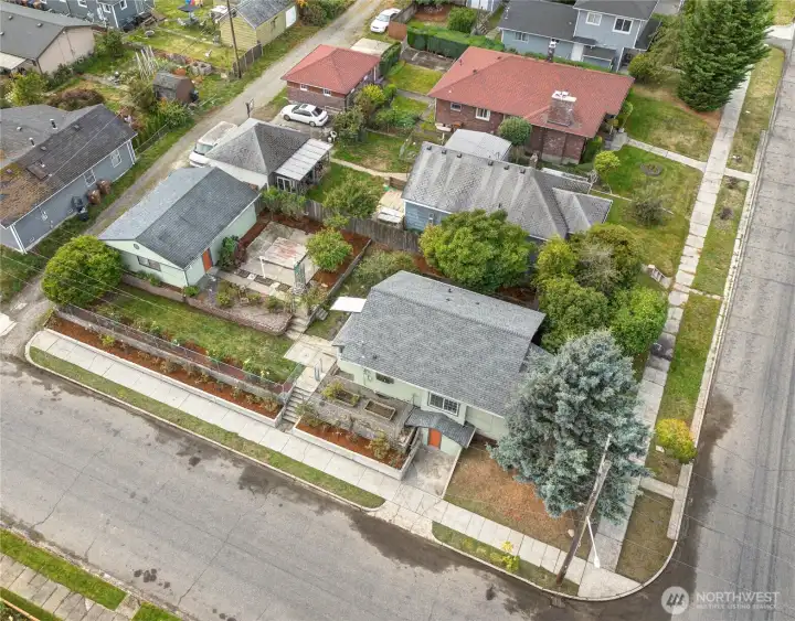 The corner lot includes a 2-car garage and fenced garden bordered by roses. There's plenty of space for parking along the street in this neighborhood with paved sidewalks, and a planting strip along the curb.