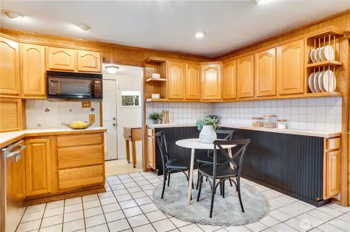 The tiled, eat-in kitchen is wrapped by cabinets for ample storage. An enclosed porch leads to the fenced back garden.