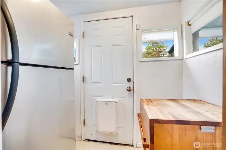 The bright, enclosed back porch has room for a fridge and butcher block. Outside, raised beds are just around the corner for fresh lettuce, tomatoes, basil, kale, or whatever you like to grow.