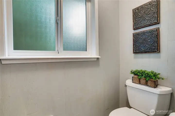 A privacy glass window opens to the west side yard where a magnolia tree grows.