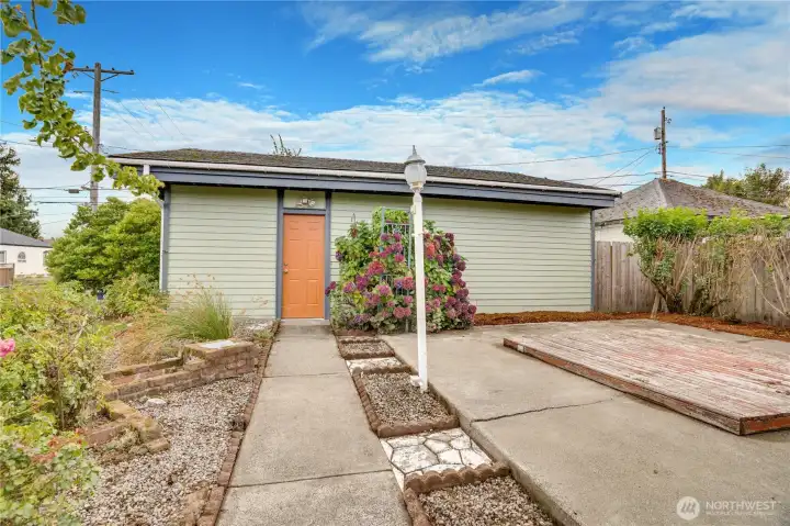 This paved path leads from the back door of the house straight to the workshop room of the garage.
