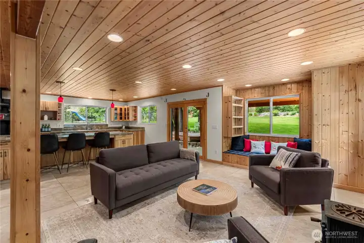 With its seamless flow from kitchen to gathering space - and cozy window seat made for quiet moments, this open-concept great room is perfect for everything from casual hangouts to lively dinner parties, all set against a backdrop of greenery just outside.