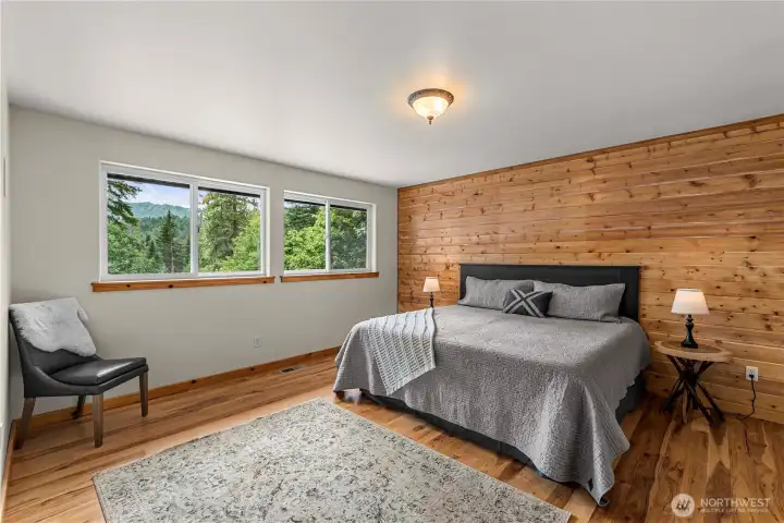 Wake up to forest and mountain views from this peaceful primary suite, where warm wood accents and natural light create a calming retreat to start and end your day in harmony with nature.