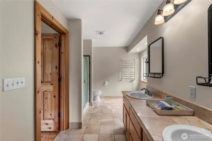 The primary bath offers a serene start and end to your day, featuring dual sinks, a walk-in shower and radiant natural light.