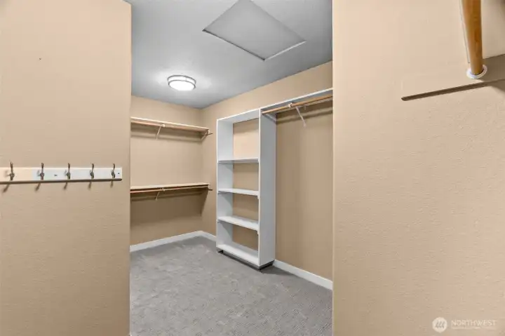 The walk in closet in the primary bathroom. Roomy with storage space.