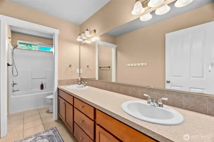 Large upstairs hall bathroom. Notice the door between the toilet/shower area and the vanity. And that's one long mirror!