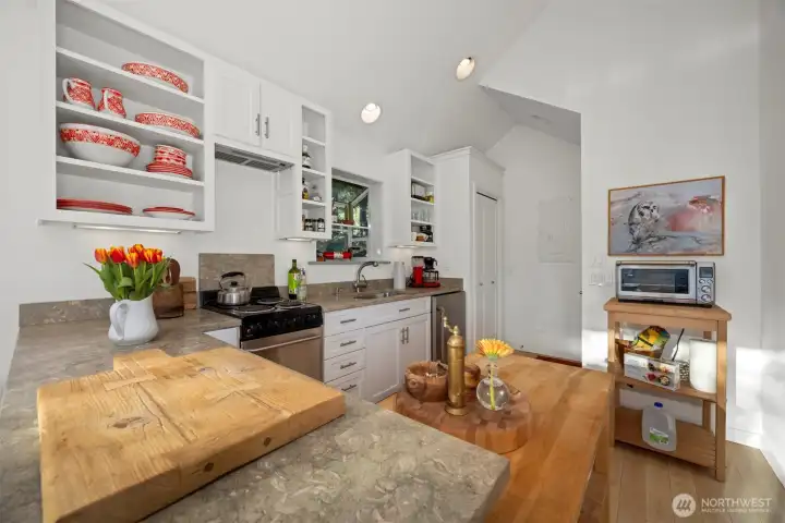 The kitchen has open shelving above and an a lot of storage white shaker in the drawers and cabinets. The kitchen has open shelving above and an a lot of storage white shaker in the drawers and cabinets.