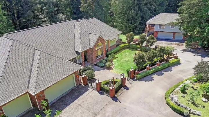 Main home w/ 3 car garage, guest house with 3 car garage in the distance.