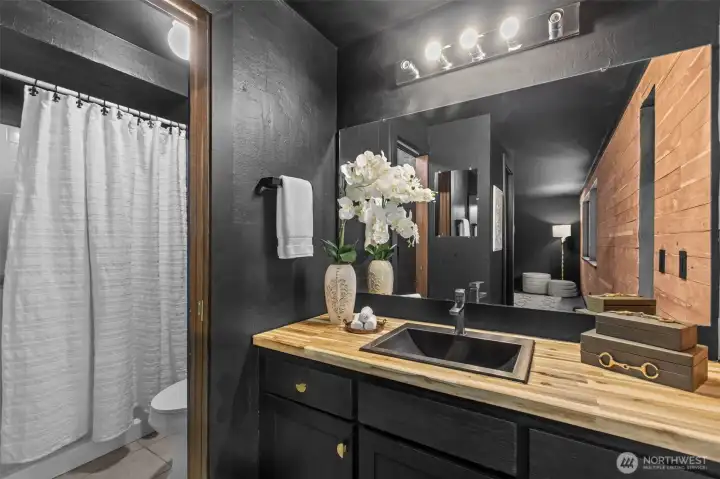 Wooden accents and black finishes continue to the en suite bathroom Wooden accents and black finishes continue to the en suite bathroom