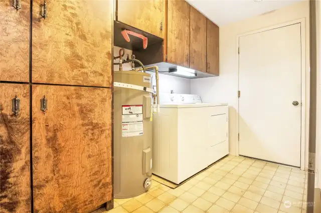 The laundry room offers plenty of additional storage. The door leads to the heated shop/rec room.