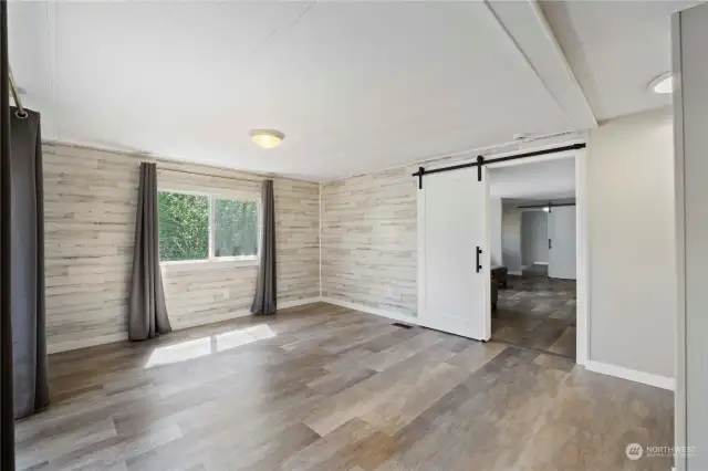 Primary suite with rustic accent walls and barn doors.