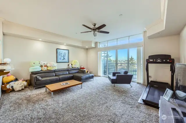 Bright and spacious living room with crown moulding detail and transom windows.