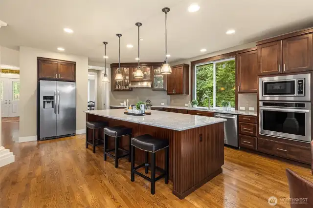 The expansive chef's kitchen features commercial stainless-steel appliances, 6 burner gas range, custom cabinetry, convection oven, granite counters, and a butler’s pantry.