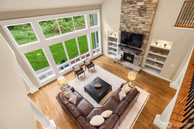 Great room inspired! Floor to ceiling windows highlighting the natural setting beyond. Stone faced gas fireplace flanked by bookshelves.