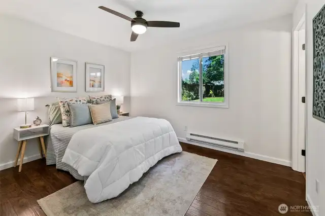 Primary bedroom overlooks backyard and has ceiling fan and ensuite bath.