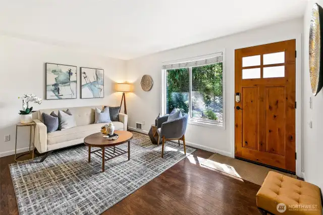 Bright living room with LVP flooring is one of two living areas.