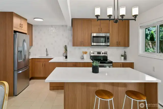 Updated kitchen in 2023 features rift white oak cabinets, quartz counters, stainless appliances, and tiled wall backsplash!
