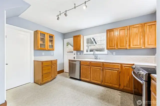 Kitchen with plenty of floor space and stainless appliances.
