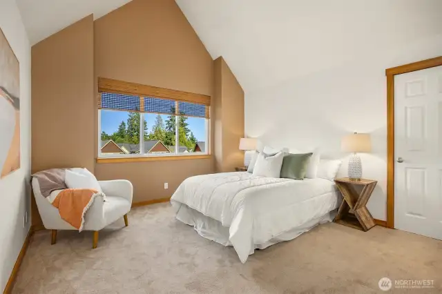 On the upper floor find two bedrooms, including this spacious primary with vaulted ceilings, two closets (one walk-in) and ensuite bathroom.