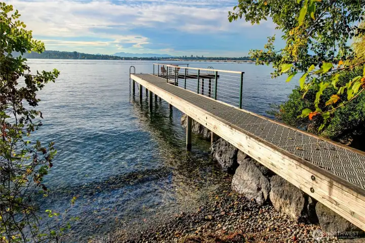 The property's private dock stretches elegantly into the tranquil waters of Lake Washington, offering an unparalleled invitation to swim, launch a kayak, or simply sit and take in the sights and sounds of the water. Tucked into a quiet cove along Evergreen Point, this intimate lakeside perch is a sanctuary for those who cherish both privacy and proximity to nature.