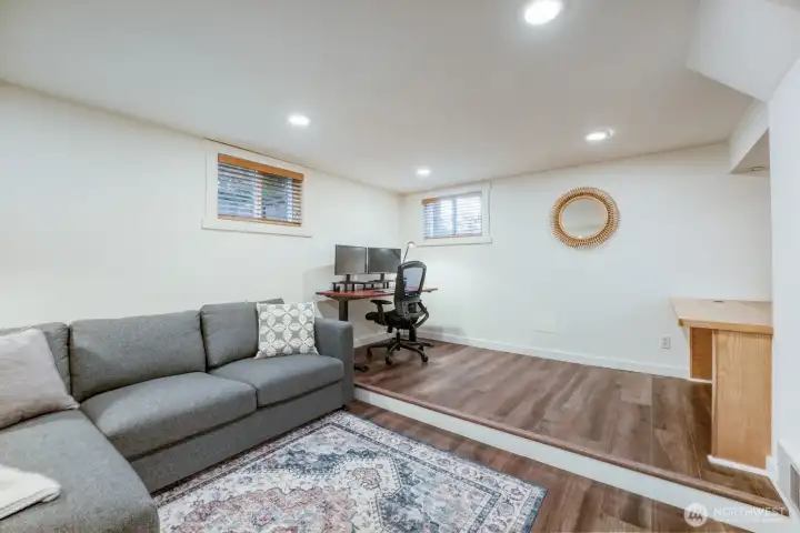 Lower level area with rec room space and raised area for den/office or yoga area.