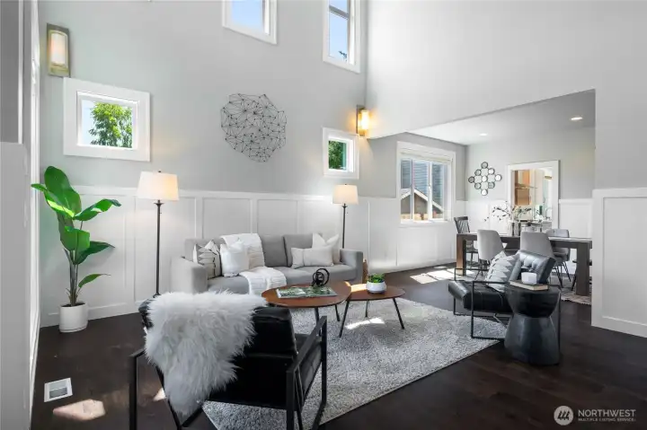 Dramatic living room with soaring two-story ceilings and board and batten wainscoting.