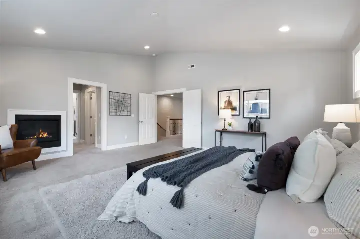 Vaulted primary suite with walk in closets, gas fireplace & en suite.