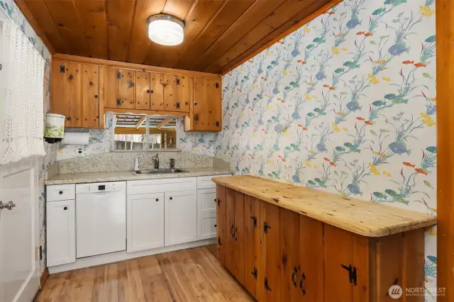 Kitchen featuring additional counter space and sink framed by window allowing light to flow in.
