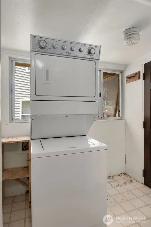 Laundry/storage area with natural light streaming through windows.