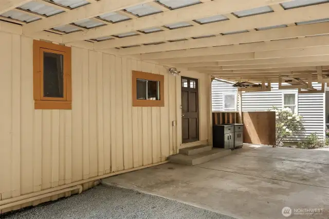 Covered back area of home featuring back door leading to interior.