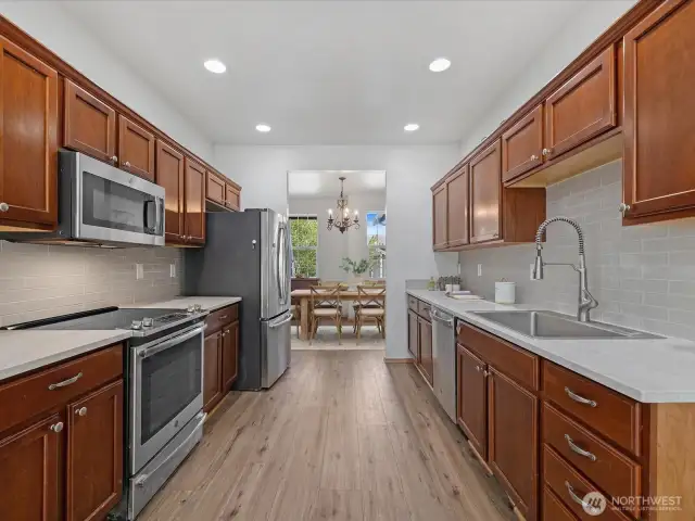 The updated kitchen is the heart of the home, featuring brand-new countertops, modern backsplash, and ample cabinetry for storage.