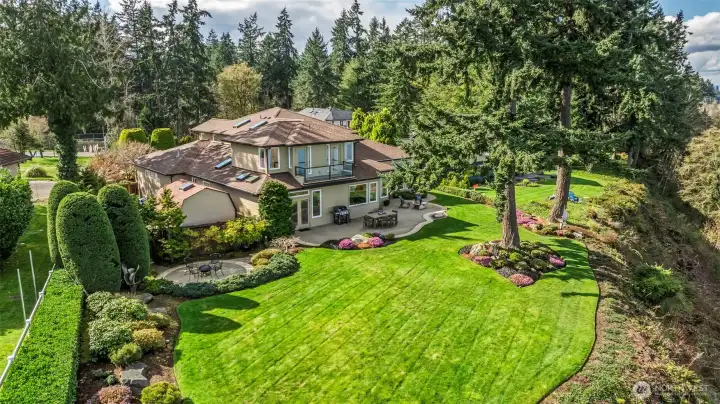 A lux landscape of beautiful gardens and patios.  Note the round patio, slightly sunken and protected - perfect for a blustery sunny day.