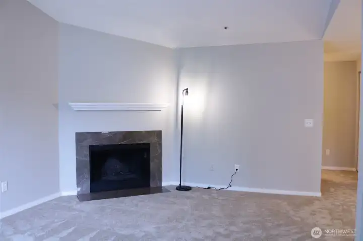 living room with vaulted ceiling, wood fireplace, new carpet throughout